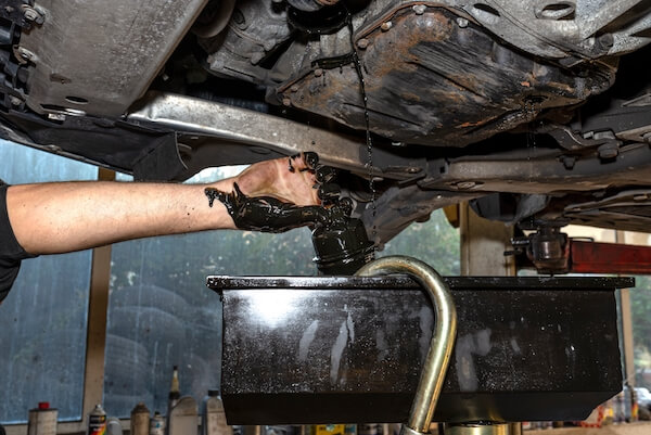 mechanic unscrews oil filter